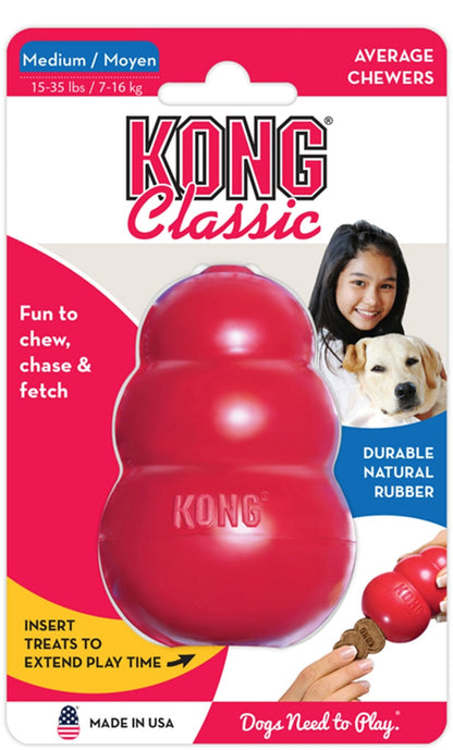 Red KONG Classic rubber dog chew toy in medium retail package with dog at side.