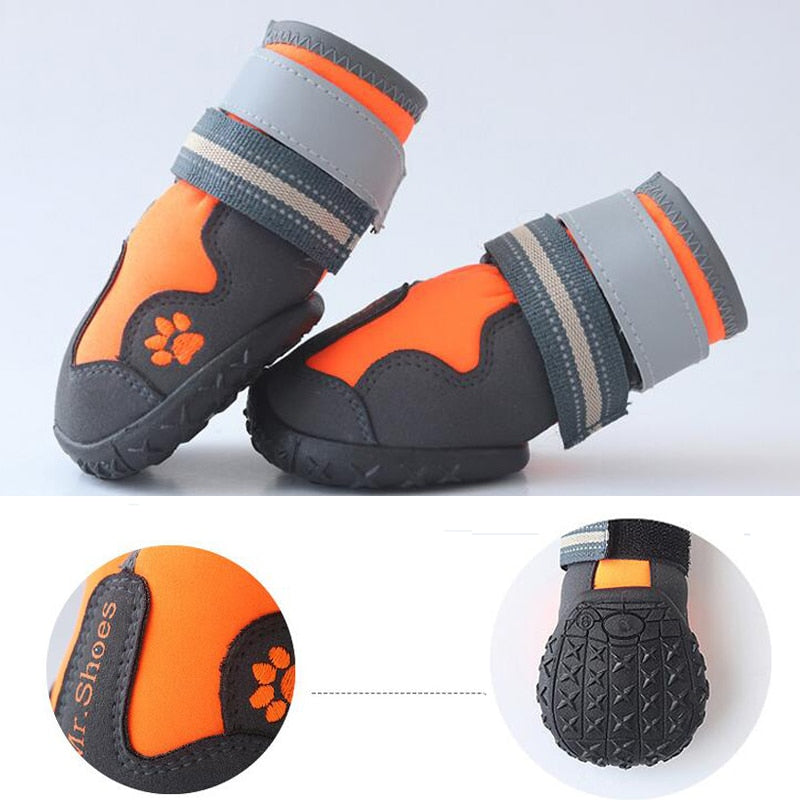 Orange and black dog waterproof booties with gray straps and paw patch