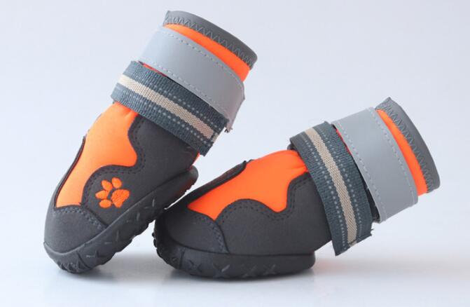 Pair of orange-and-black dog waterproof booties with gray hook-and-loop cuff