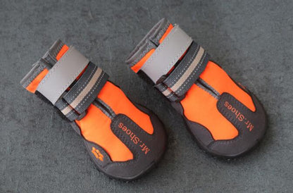 Orange and black dog waterproof booties laid on gray floor
